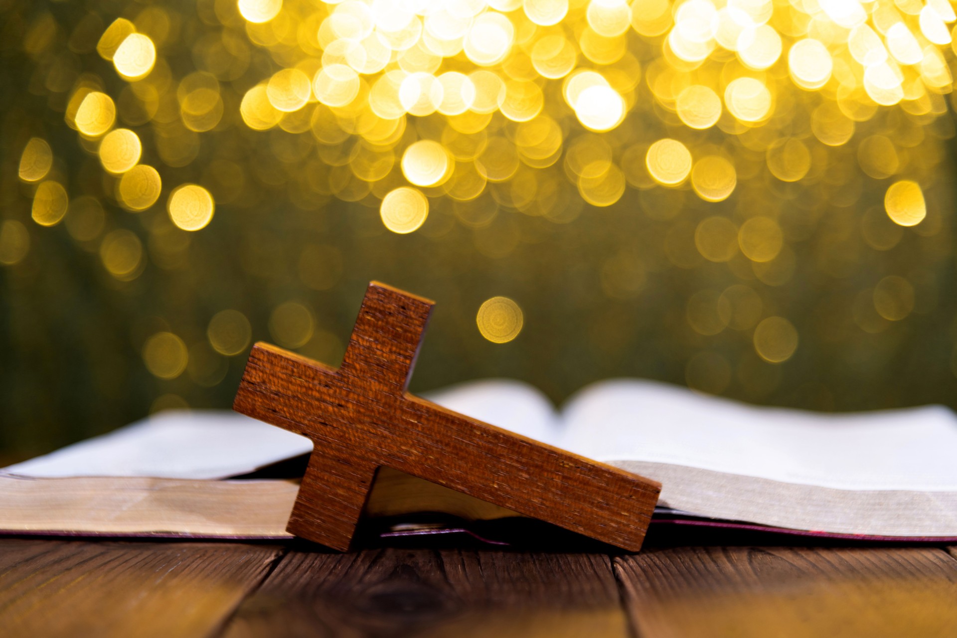 Bible and religious cross on wooden table